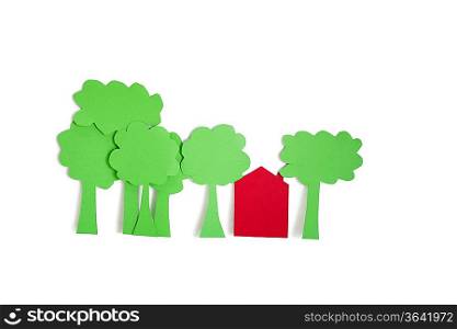 Paper cut outs of trees with a residential house over white background