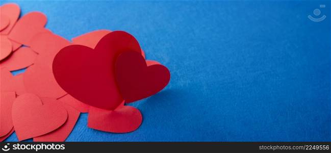 Paper cut red hearts shape on blue background. Panoramic image with copy space. Concept image. Valentine&rsquo;s day, mother&rsquo;s day, birthday greeting cards, invitation, celebration
