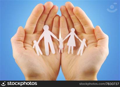 Paper family in hands isolated on blue background