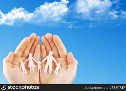 Paper family in hands isolated on blue sky