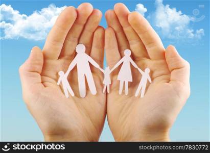 Paper family in hands isolated on blue sky
