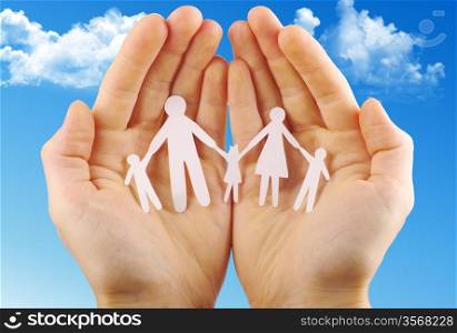 Paper family in hands isolated on blue sky&#xA;