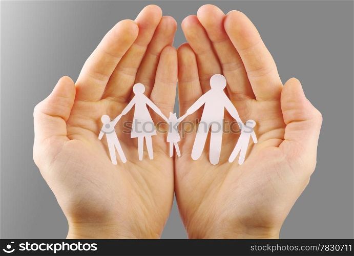 Paper family in hands isolated on grey background