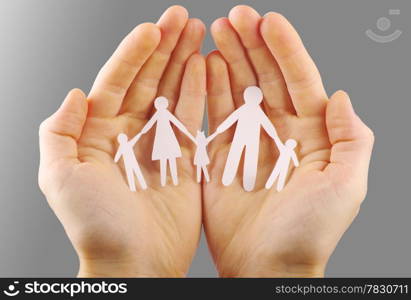 Paper family in hands isolated on grey background