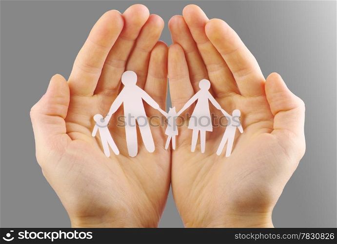 Paper family in hands isolated on grey background