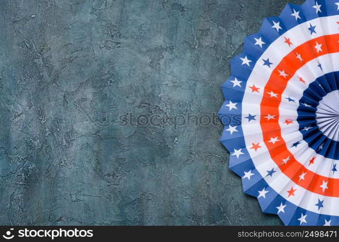 Paper fan US flag color style on grunge rustic background flat lay.