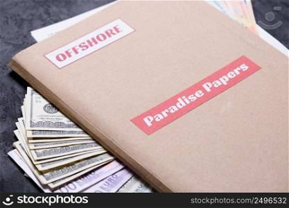 Paper folder with Paradise papers label on it with euro and dollar currency, offshore tax heavens documents leak concept