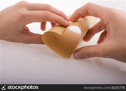 Paper forming a heart shape. Paper forming a heart shape in hand on a white background