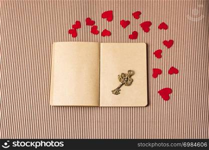 paper hearts around notebook with a decorative retro key