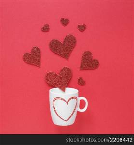 paper hearts scattered from cup