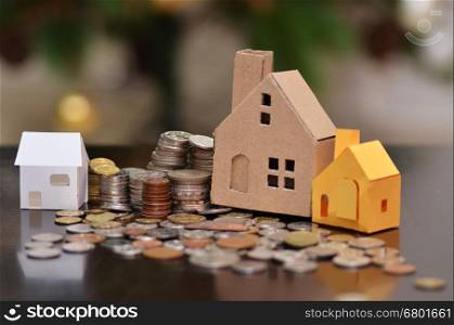 Paper house and stacks of coins standing. House loan concept