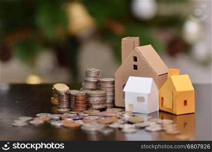 Paper house and stacks of coins standing. House loan concept