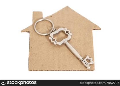 Paper house with key isolated on white