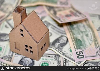 Paper made house stands on dollar money