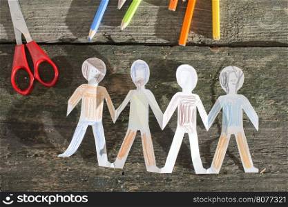 Paper made people figures. Painted white figures on wooden board