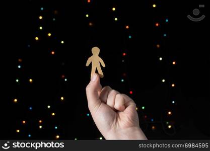 Paper man shape in hand on bokeh light background