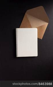Paper notebook or notepad and envelope at black background texture. Creative idea concept