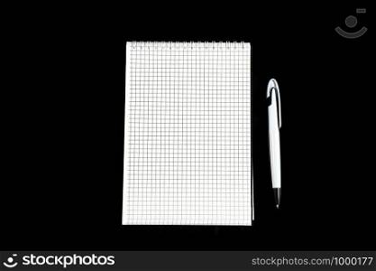 paper notebook with ballpoint pen on black isolated background