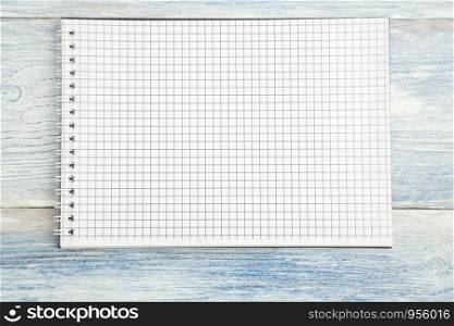 paper notebook with space for text on a light blue old wooden background. top view. flat lay