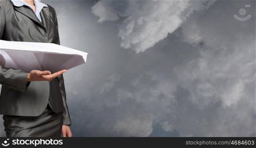 Paper plane in hands. Close view of businesswoman holding paper plane in hand
