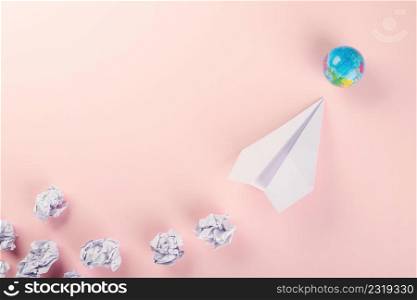 Paper plane tourism. Top view mock up design of airplane travel and globe, education or innovation origami plane, isolated on pink background, world of flight transportation