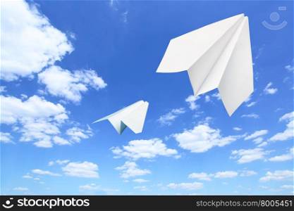 Paper planes flying. Sky and clouds in the background