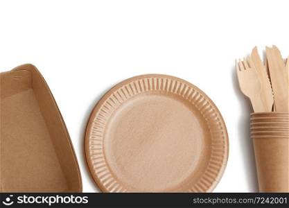 paper plates and cups from brown craft paper and wooden forks and knives isolated on a white background. Plastic rejection concept, zero waste