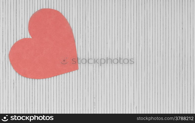 Paper red heart love symbol on grey gray bamboo mat copy space for text as valentines day concept