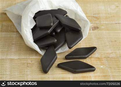 Paper sack with black salt licorice confection, a Dutch candy called drop