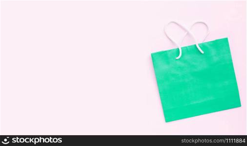 Paper shopping bag on pink background.