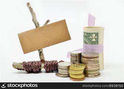 Paper sign board with stack of coins on white background
