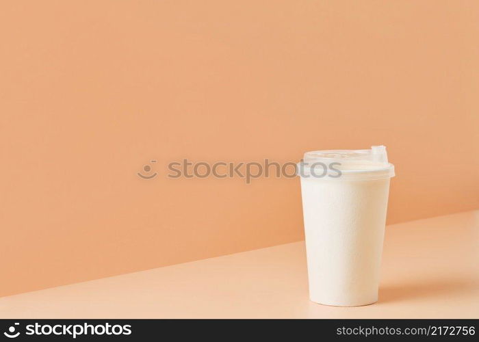 Paper unbranded white glass for drinks on a colored background, close-up with copy space for text.Cardboard eco-friendly cup