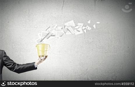 Paper work. Close up of businessman holding yellow bucket in hand