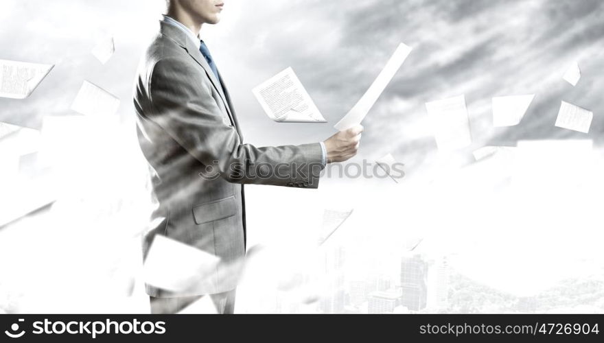 Paperwork. Back view of businessman reading documents in hand