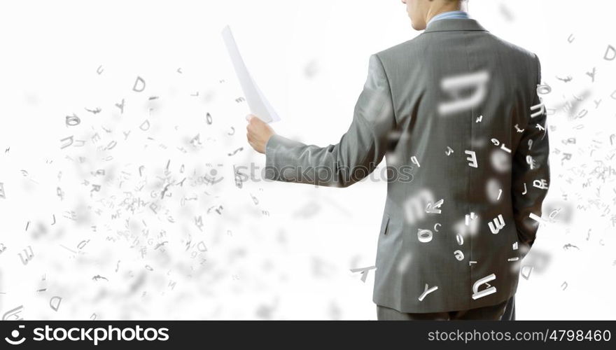 Paperwork. Back view of businessman reading documents in hand