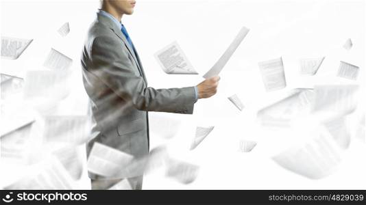 Paperwork. Back view of businessman reading documents in hand