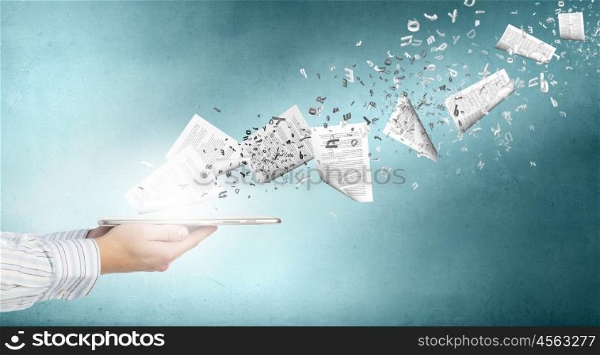 Paperwork. Tablet pc in businessmans hand and papers flying of screen