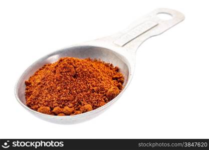 paprika powder on an old aluminum measuring spoon isolated with a clipping path