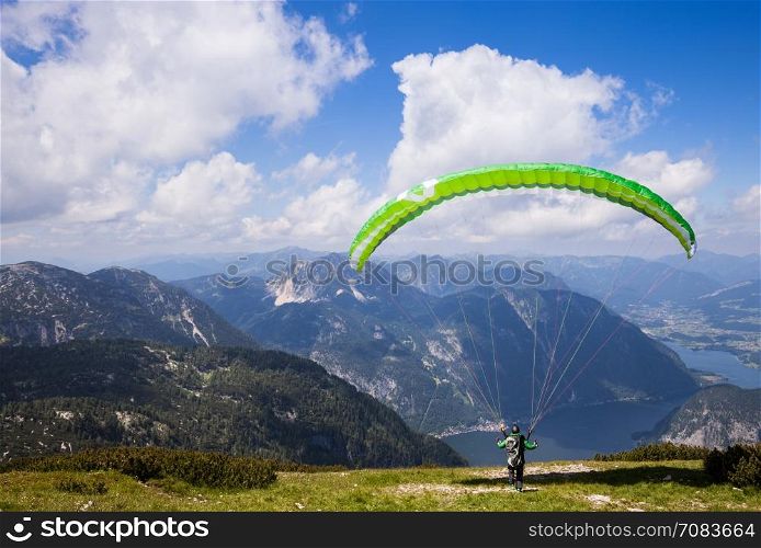 Parachute jumping extreme sport. Paraglider flying over mountains in summer day