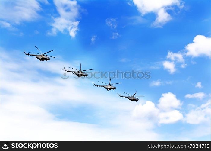 Parade of four war helicopters in the blue sky