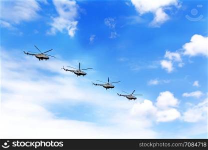 Parade of four war helicopters in the blue sky