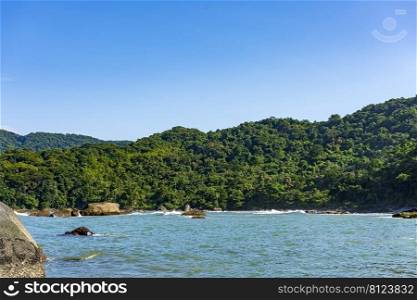 Paradise rocky tropical beach with mountains and forests around in coastal Bertioga of Sao Paulo state, Brazil. Paradise rocky tropical beach with mountains and forests around