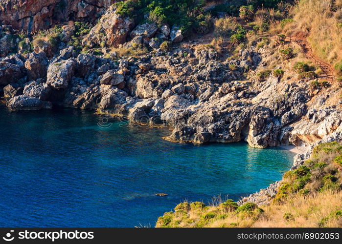 Paradise sea bay with azure water and beach. View from coastline trail of Zingaro Nature Reserve Park, between San Vito lo Capo and Scopello, Trapani province, Sicily, Italy.