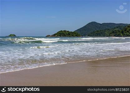 Paradise tropical beach with clean and calm waters surrounded by rainforest and hills in Bertioga coast of Sao Paulo state, Brazil. Paradise tropical beach with clean and calm waters surrounded by rainforest and hills