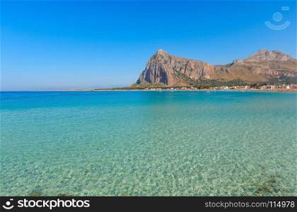 Paradise Tyrrhenian sea bay, San Vito lo Capo beach with clear azure water and extremally white sand, and Monte Monaco in far, Sicily, Italy. People unrecognizable.