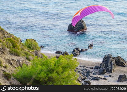 Paraglider flying over beach sea shore. Paragliding. Extreme sport.. Paraglider flying over sea shore