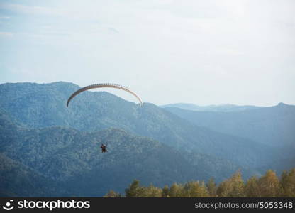 Paragliding in mountains. Para gliders in fight in the mountains, extreme sport activity.. Paragliding in mountains