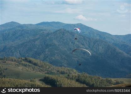 Paragliding in mountains. Paragliding in mountains. Para gliders in fight in the mountains, extreme sport activity.