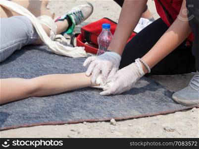 Paramedic bandaging the hand of an injured person