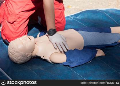 Paramedic demonstrates first aid on a CPR dummy